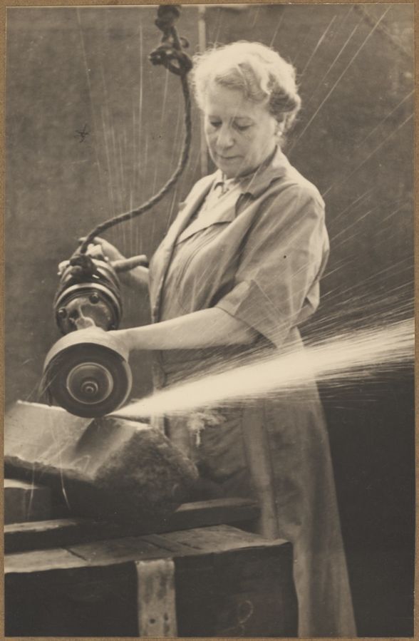 Women_volunteer_grinding_a_billet_of_armour_piercing_steel_at_a_munitions_factory,_Australia,_1944._(8676960558)